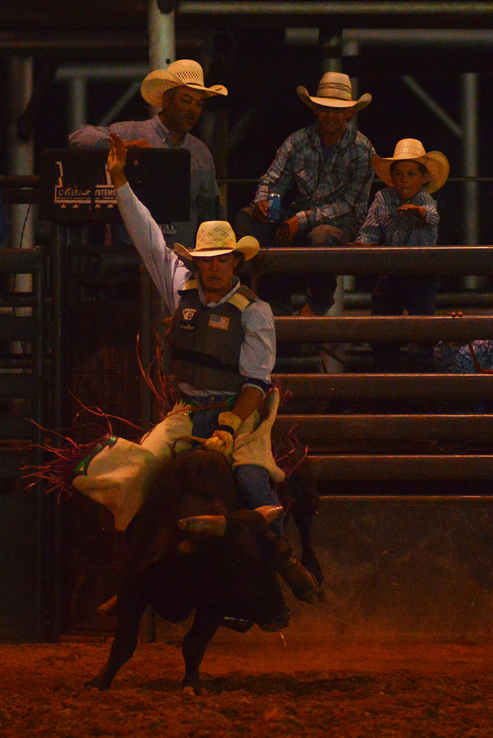 Kyler Ostler throws his hand up as his bull lands